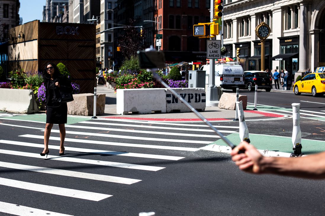 A woman uses a new 24th Street crosswalk to cross Broadway. Department of Transportation officials installed the new walkway after closely studying the intersection and finding that thousands of pedestrians each day would venture into traffic and cross at the intersection, despite the previous lack of a signal and crosswalk.</br>